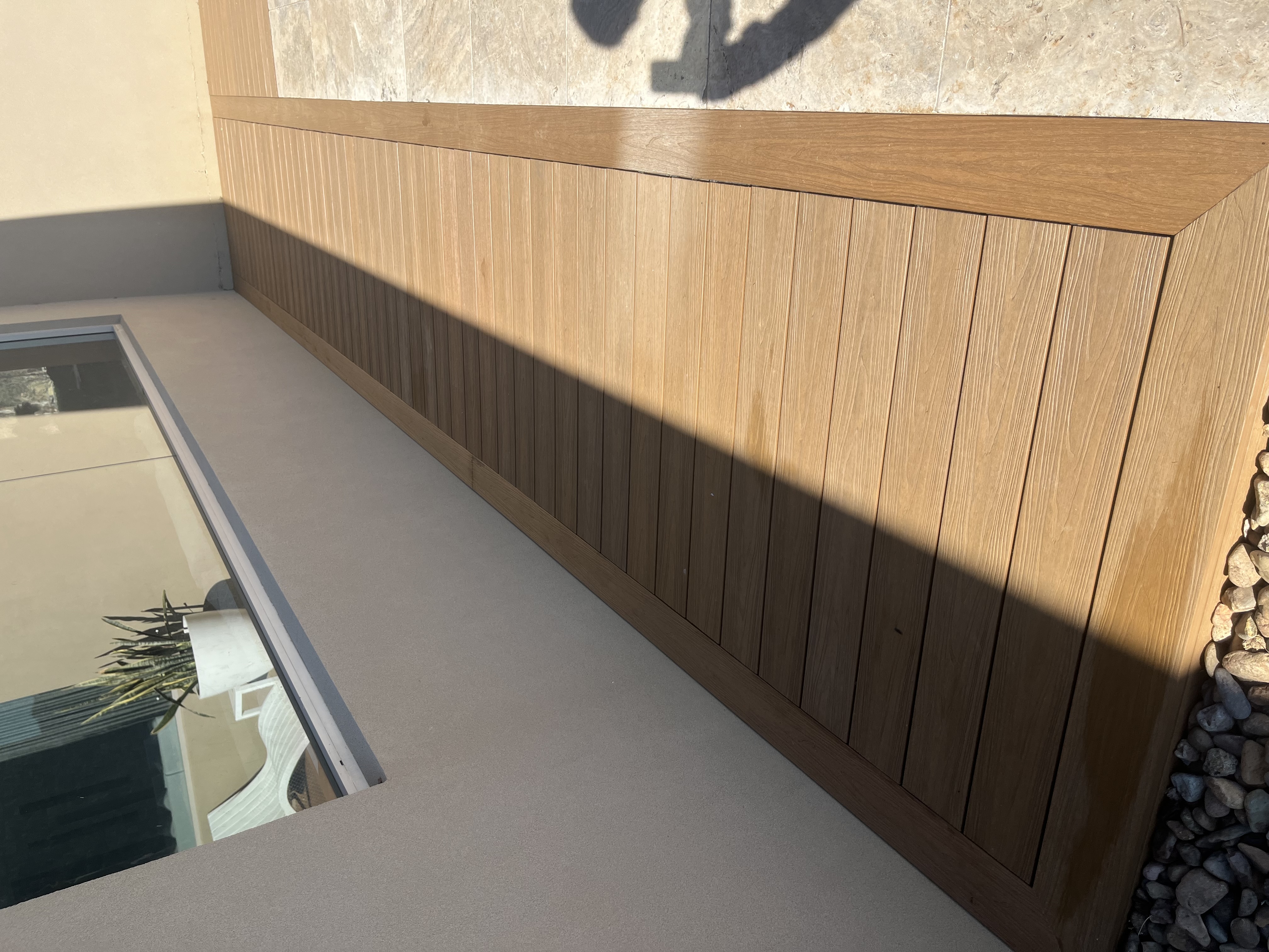Composite walkway beside a rendered wall