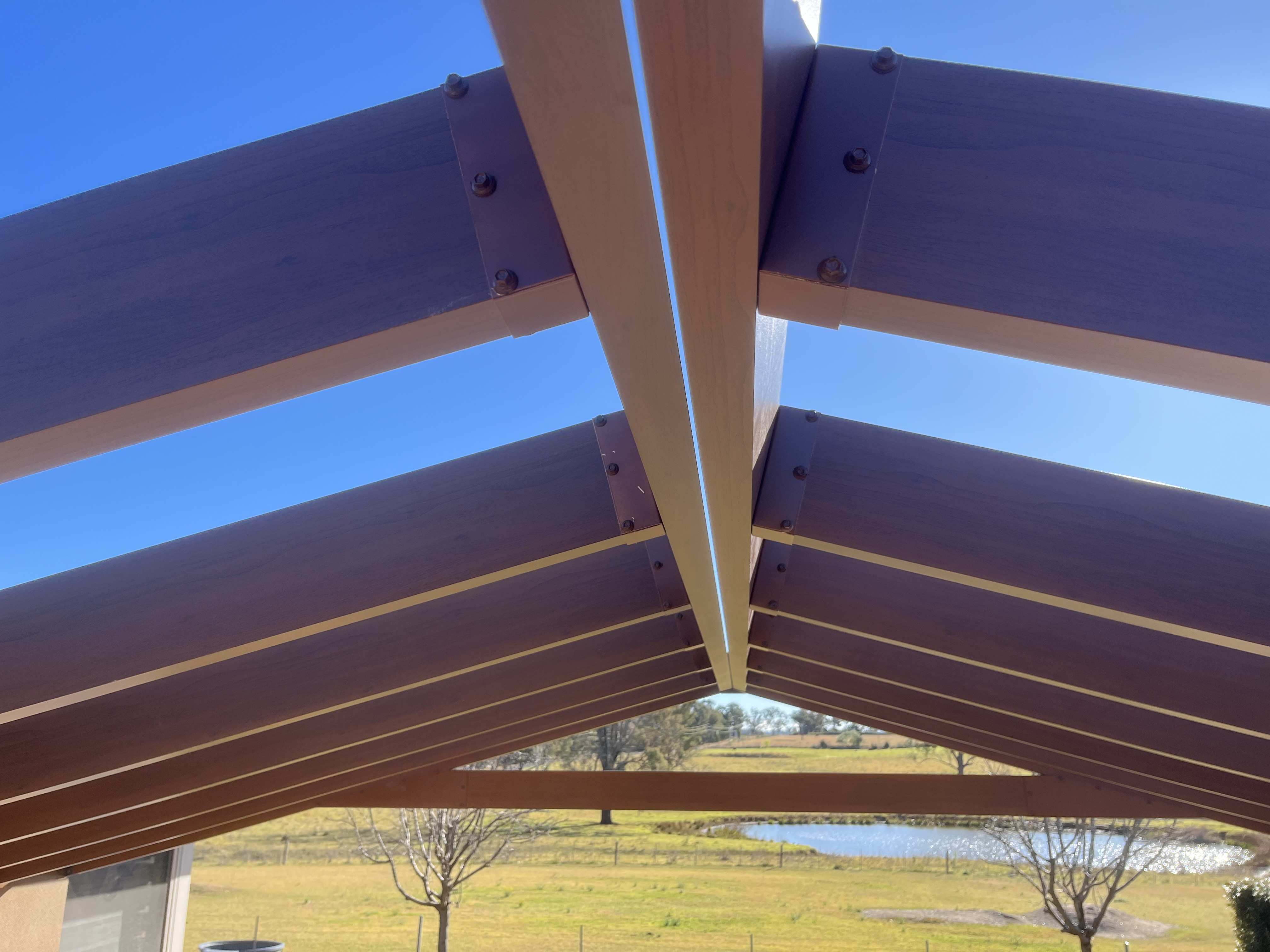 Timber pergola beams against blue sky